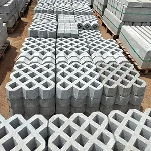 imagem com diversas concregramas de concreto empilhadas e enfileiradas, em cima de pallets, em um terreno de pedra britada