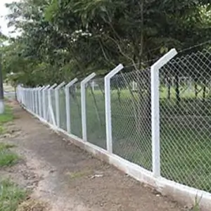 postes curvos com grade de arames instalados ao redor de um terreno com grama, cercando-o